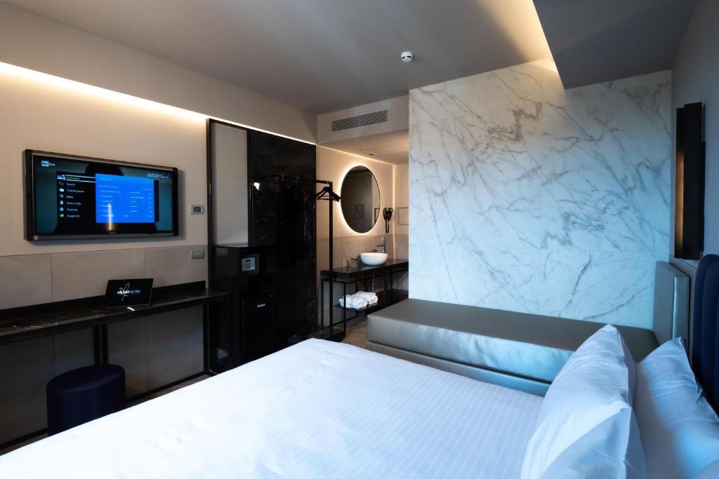 a bedroom with a bed and a tv on a wall at Heart Hotel Milano in Milan