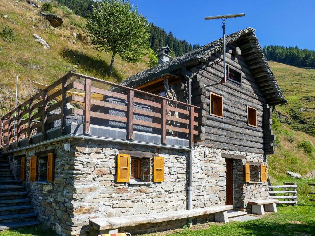 a stone house with a balcony on top of it at Holiday Home Rustico Catcüc by Interhome in Malvaglia