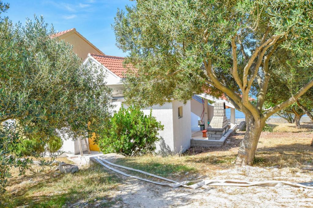 una casa con un árbol y una manguera en House Pine Shadow, en Pašman