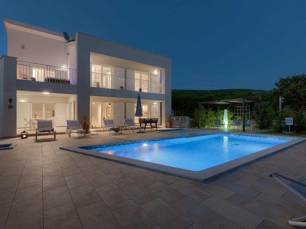 a large swimming pool in front of a house at Villa Laura by Interhome in Koromačno