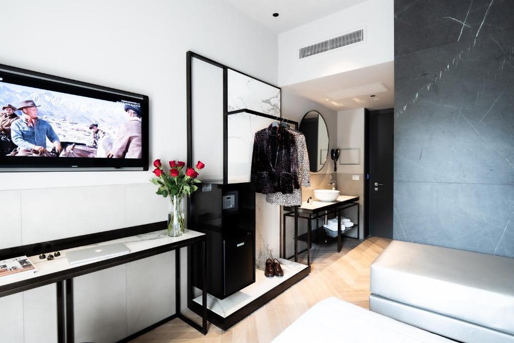 a living room with a television on a wall at Heart Hotel Milano in Milan