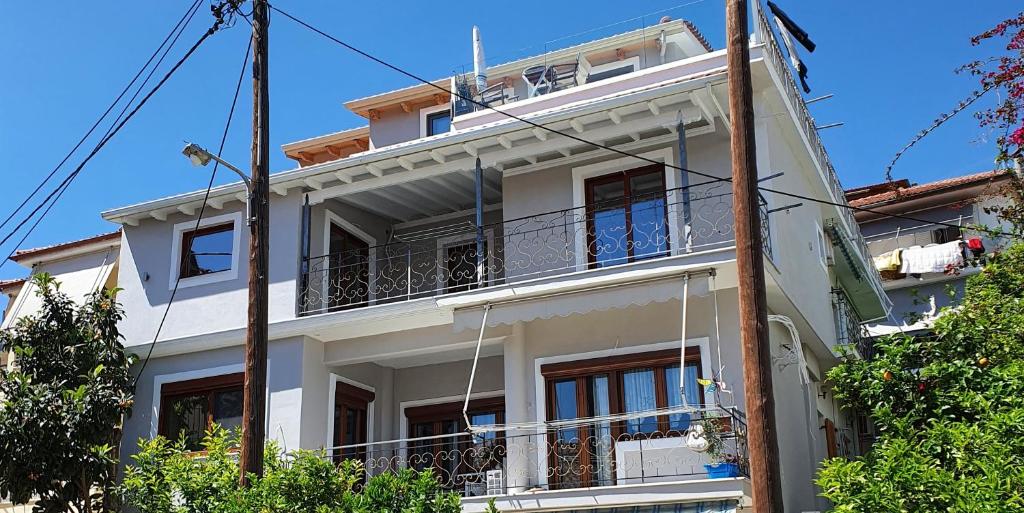 a white apartment building with a balcony at Bellos House in Parga