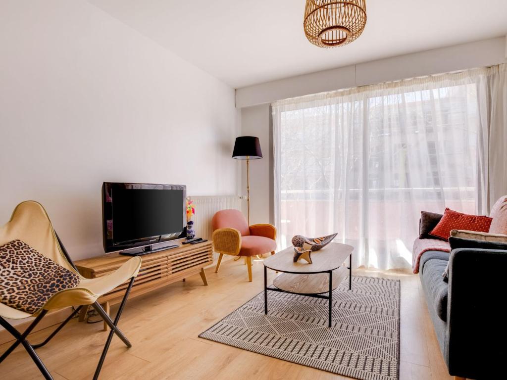 a living room with a couch and a tv at Apartment Calliope by Interhome in Arcachon