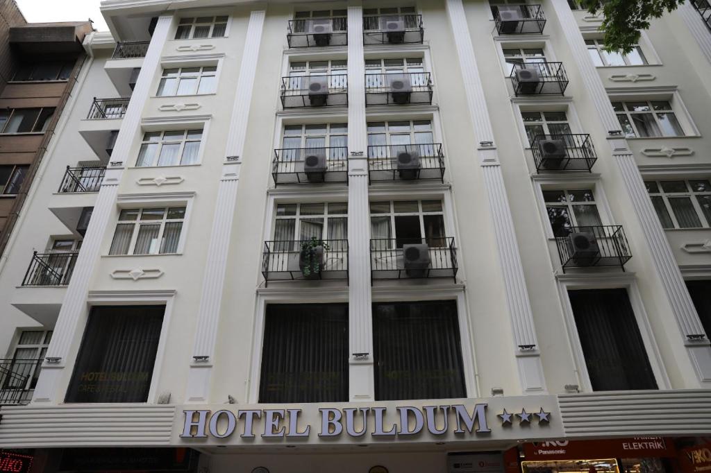 un edificio de hotel con balcones y una señal en él en Buldum Otel en Ankara