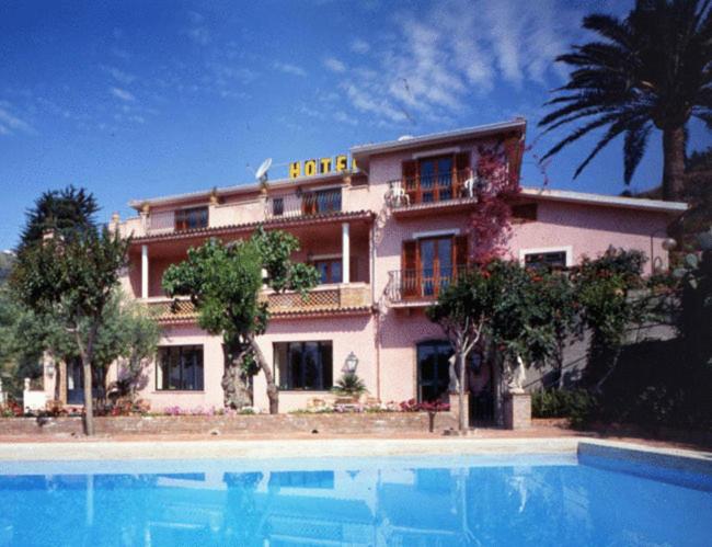 a house with a swimming pool in front of a building at Hotel Villa Sirina in Taormina