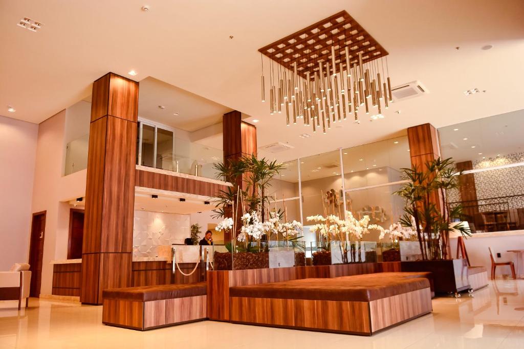 a lobby with a chandelier and a dining room at Forte Express in Macapá