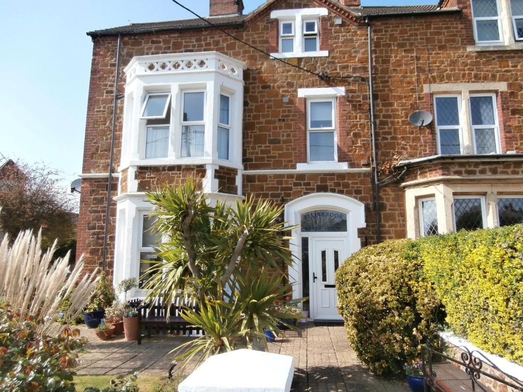 a brick house with a white door at Ellinbrook Guest House in Hunstanton