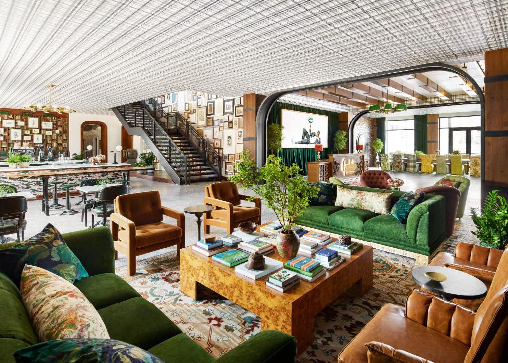 a living room with green couches and a table at Graduate by Hilton East Lansing in East Lansing