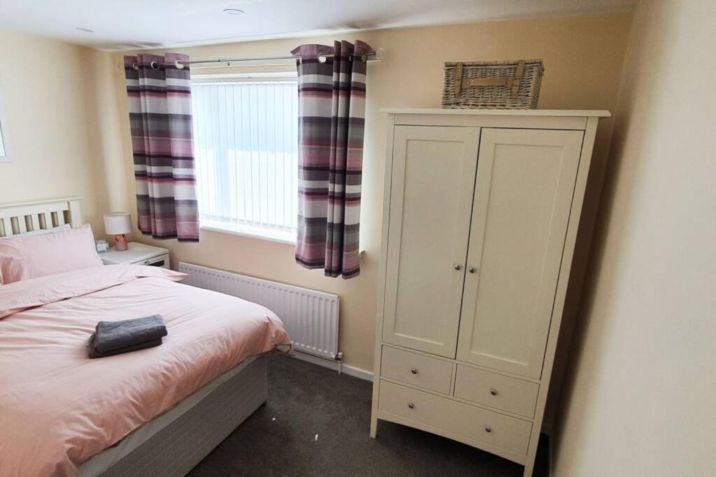 a bedroom with a bed and a cabinet and a window at Stamford - Entire 1 bed cosy home. in Stamford