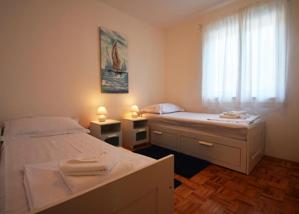 sypialnia z dwoma łóżkami i oknem w obiekcie Villa Golden Apple w mieście Seline