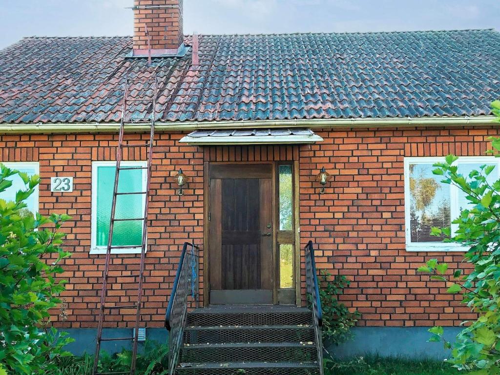 a small brick house with a wooden door and stairs at Tranquil Retreat in Halsingland-By Traum in Kårböle