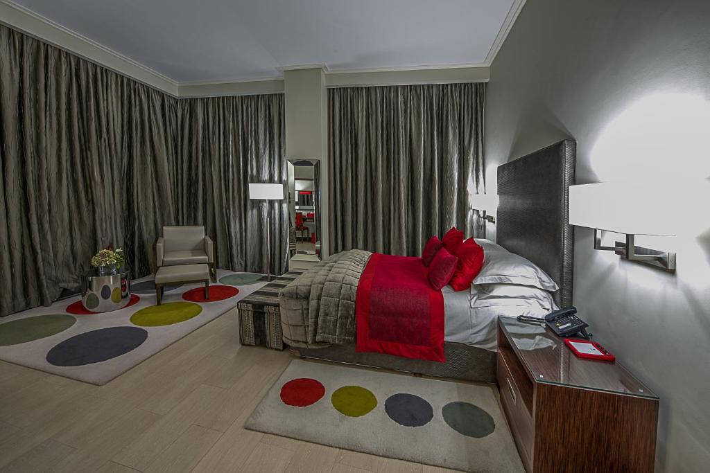 a bedroom with a bed and a desk and a chair at The George Hotel in Lagos
