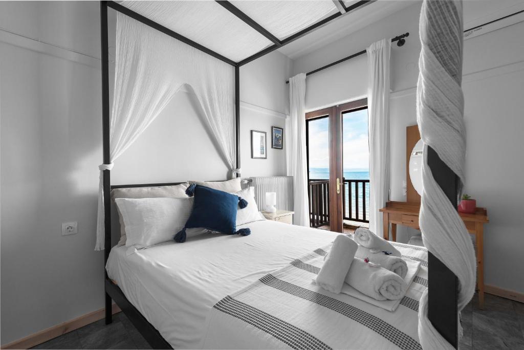 a bedroom with a white bed with a view of the ocean at Kalokerino in Olympiada