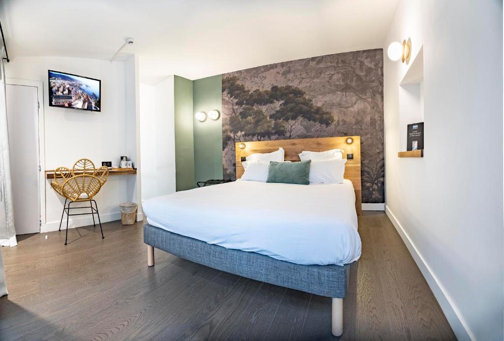 um quarto com uma cama grande e uma secretária em Monsieur Miot Concept Hotel - Bastia centre em Bastia