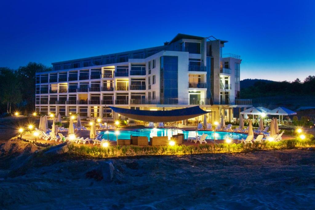 a hotel with a swimming pool at night at South Pearl in Sozopol