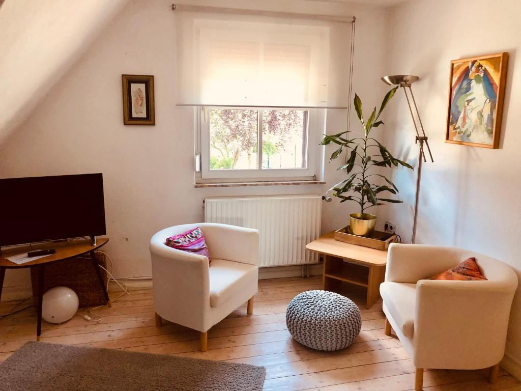 a living room with two chairs and a television at Gemütliche Fewo Nähe Hachenburg, Bad Marienberg in Langenbach bei Kirburg