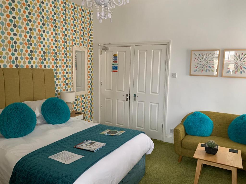 a bedroom with a bed and a couch and a chair at The Fylde International Guest House in Blackpool