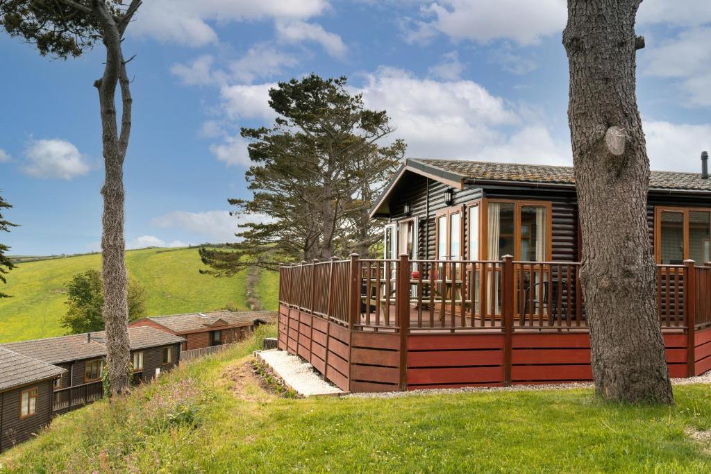 une maison avec une terrasse et un arbre dans l'établissement Finest Retreats - Whitsand Bay Lodge, à Torpoint