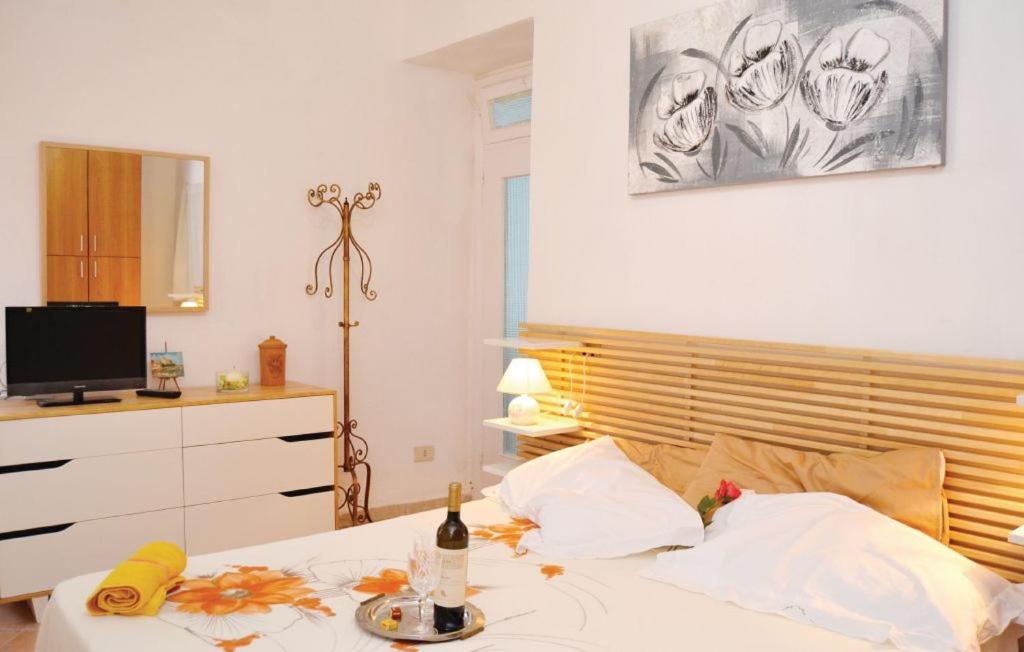 Schlafzimmer mit einem Bett mit einer Flasche Wein und einer Banane in der Unterkunft La casetta del Marinaio in Tellaro
