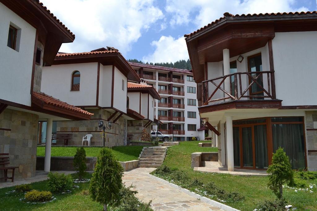 a group of buildings in a yard with grass at Forest Nook Villas in Pamporovo