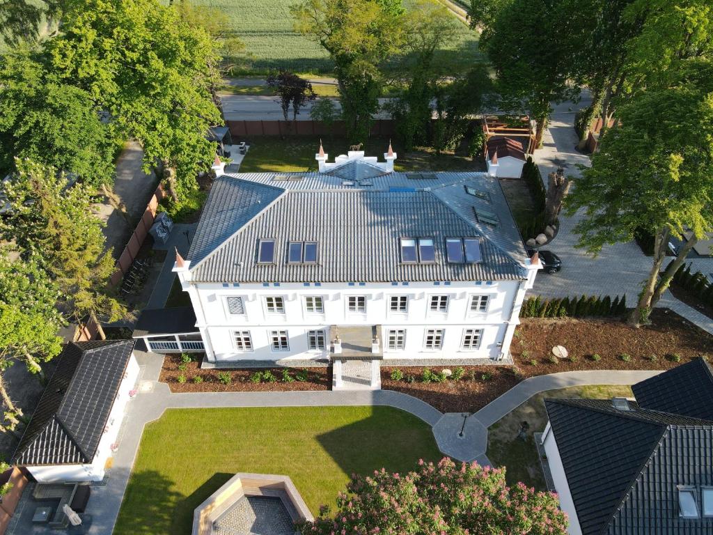 eine Luftansicht eines weißen Hauses mit einem Dach in der Unterkunft Herrenhaus-Henriettenhof in Grömitz