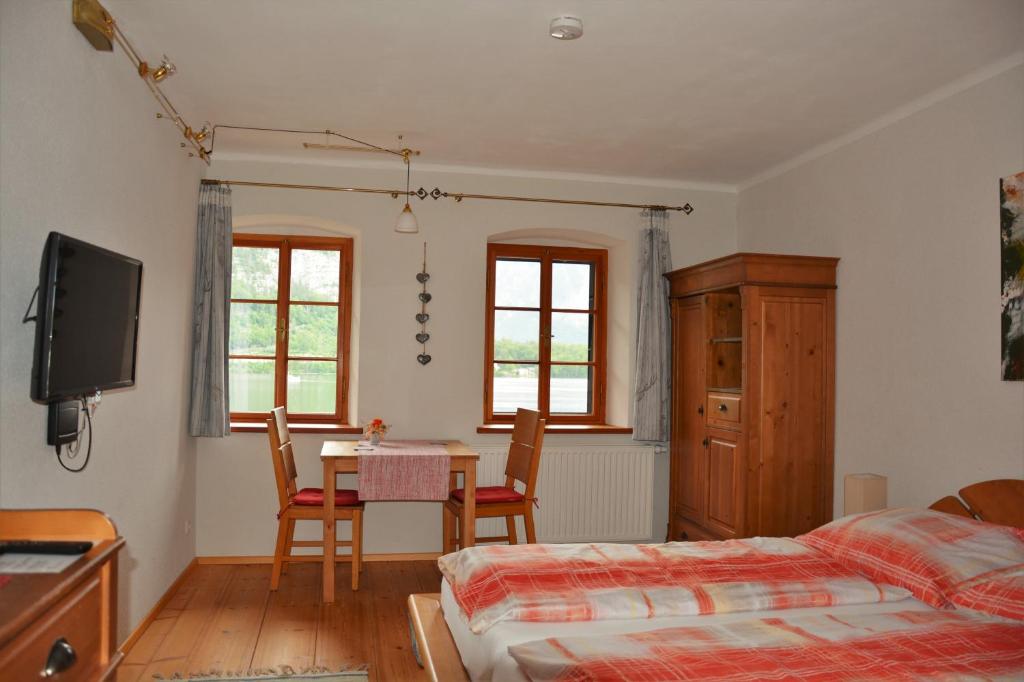 een slaapkamer met een bed en een tafel en stoelen bij Haus Franziska in Hallstatt