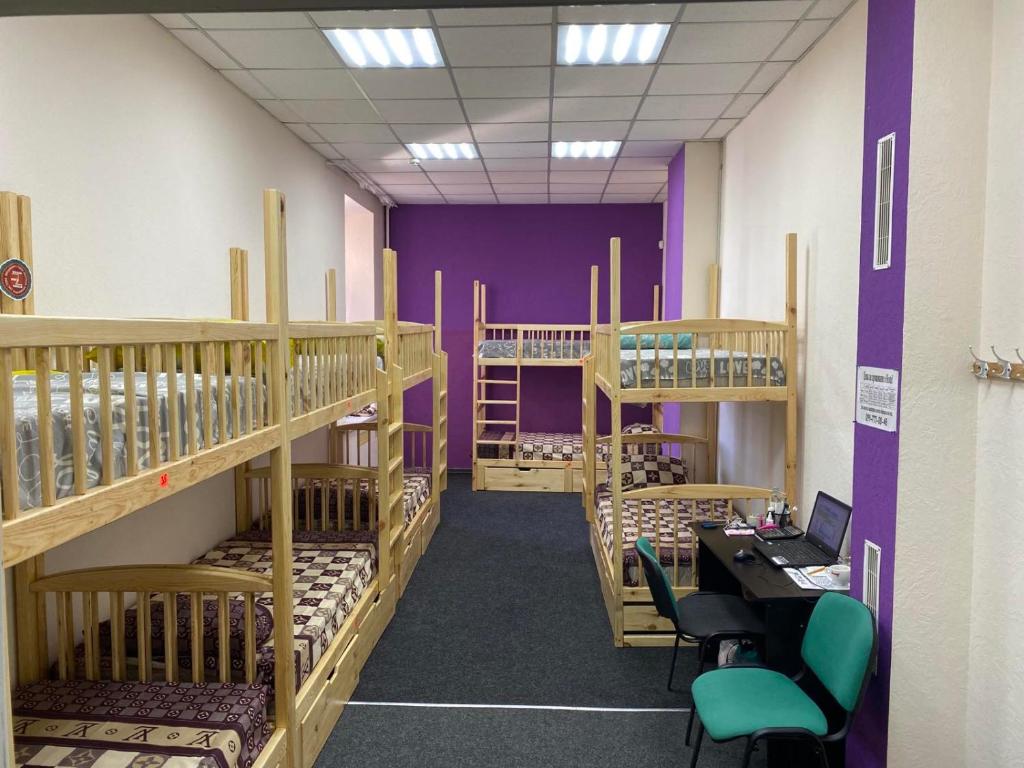 a room with multiple bunk beds and a desk with a laptop at Хостел Мажор in Kharkiv