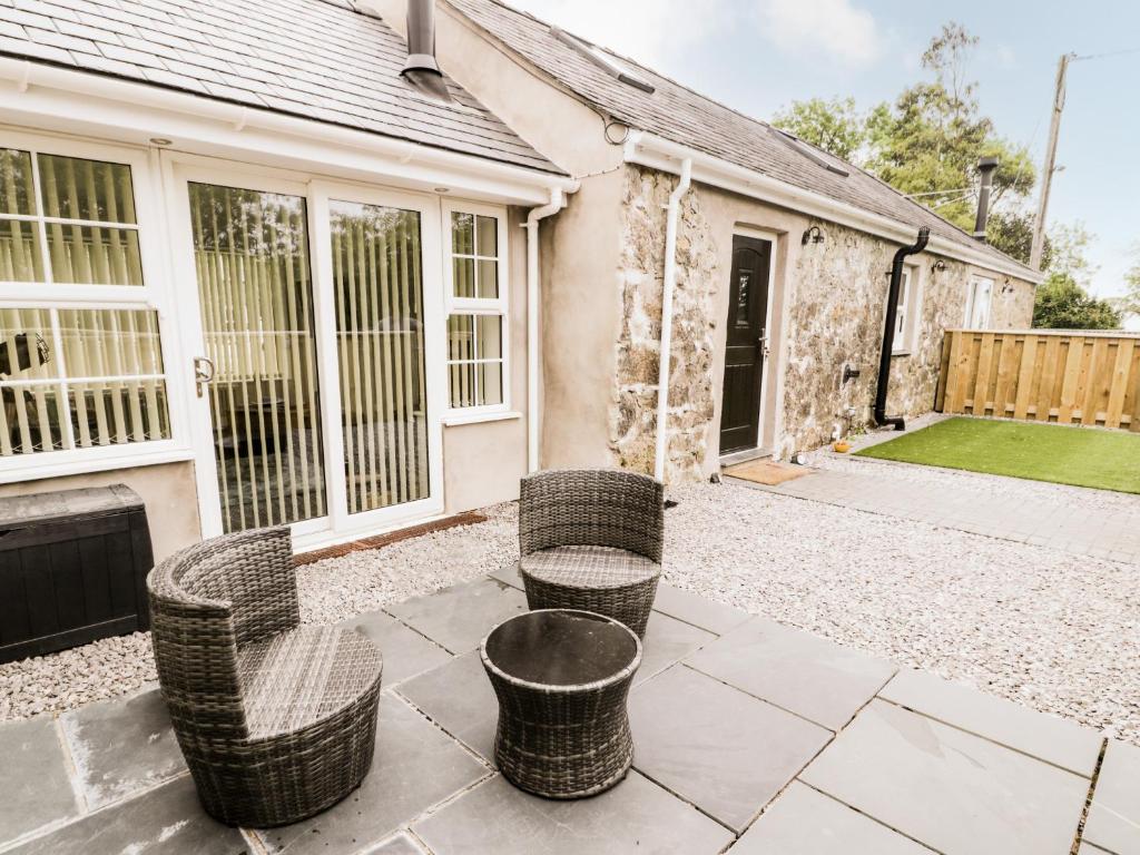 a patio with wicker chairs in front of a house at 2 Mountain View in Llangefni