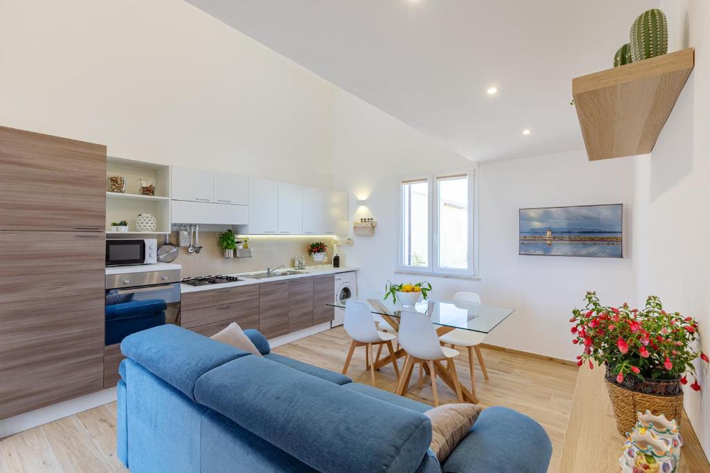 Una sala de estar con un sofá azul y una cocina. en Vento di Scirocco, en Marsala