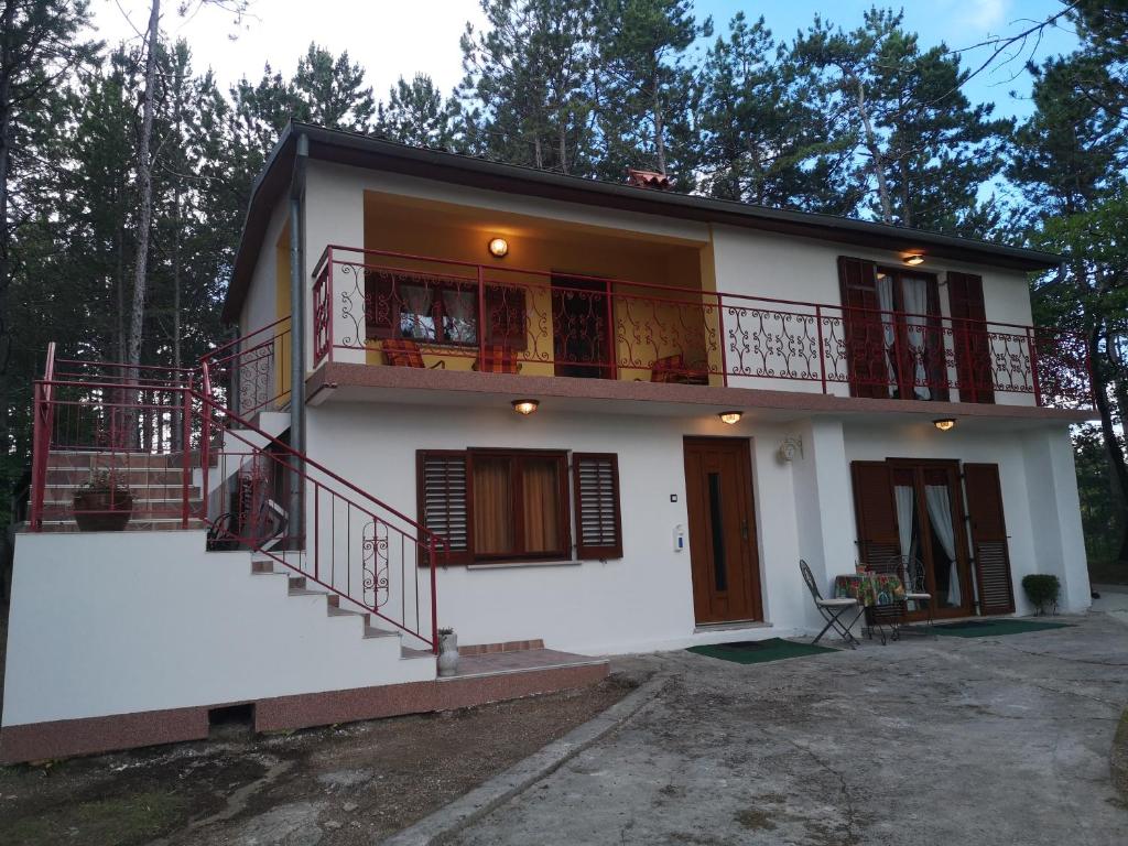 a large white house with a balcony and stairs at Pineta in Gračišče