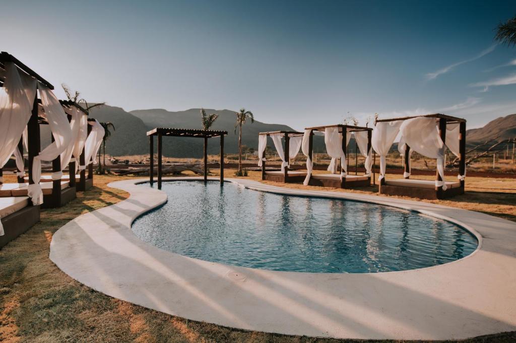 una piscina en un complejo con sillas y mesa en Hacienda Viga 2020 Hotel, en Cuatrociénegas de Carranza