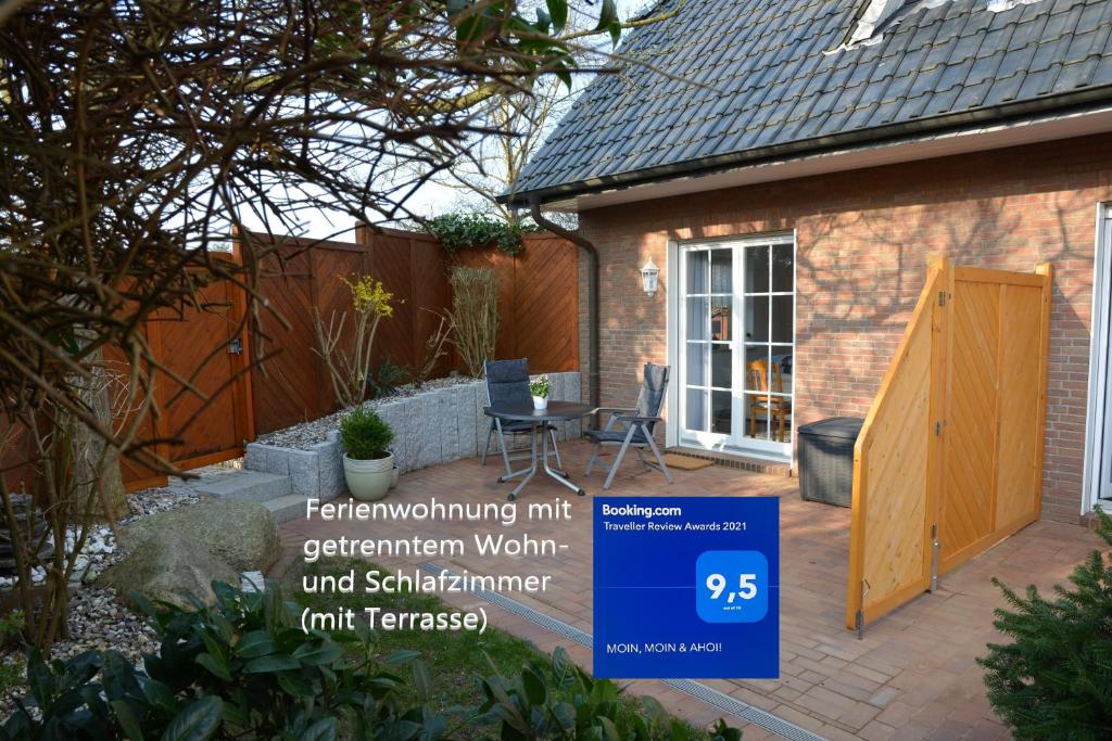 einen kleinen Garten mit einer Holztür und einer Terrasse in der Unterkunft MOIN, MOIN & AHOI! in Kiel