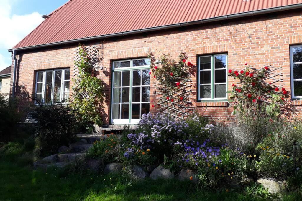 a brick house with flowers in front of it at Ferienwohnung in Seenähe in Borgdorf-Seedorf
