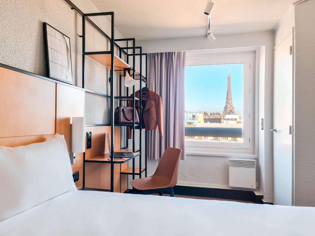 - une chambre avec un lit et une vue sur la tour Eiffel dans l'établissement Ibis Paris Tour Eiffel Cambronne 15ème, à Paris