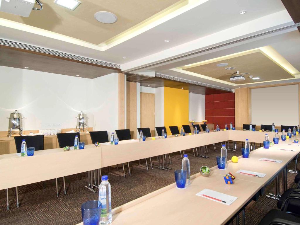 a large room with rows of tables and chairs at ibis Pune Viman Nagar - An Accor Brand in Pune