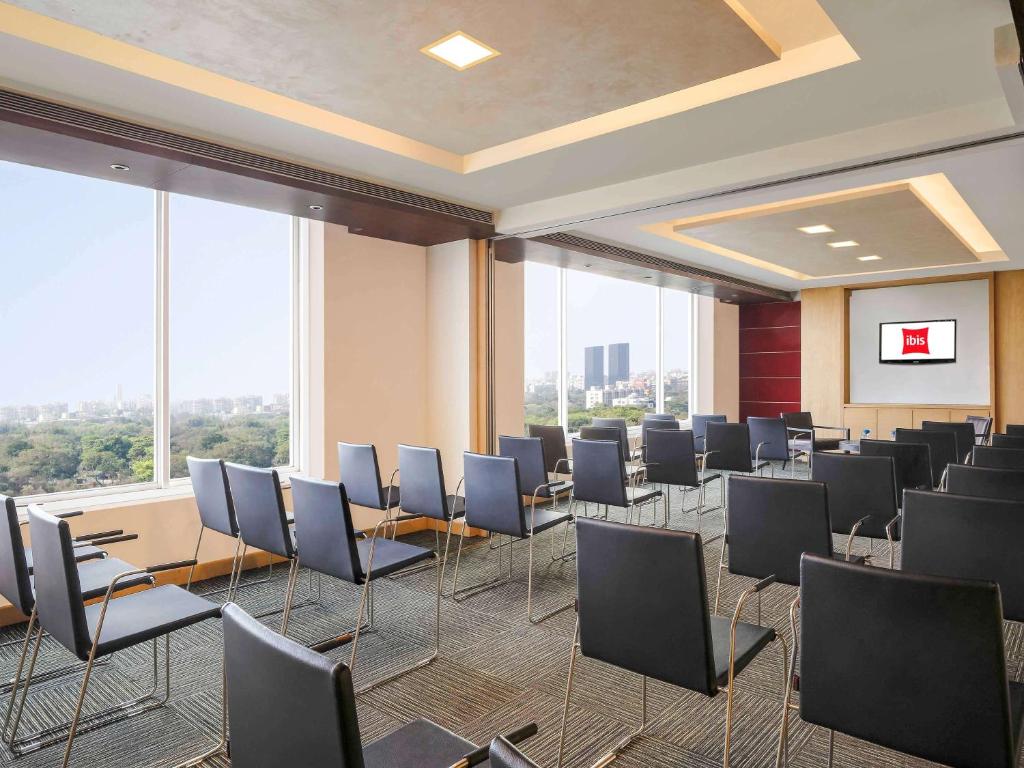 a room with rows of chairs in a room with windows at ibis Pune Viman Nagar - An Accor Brand in Pune
