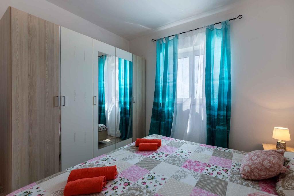 sypialnia z dużym łóżkiem z niebieskimi zasłonami w obiekcie Apartment in Liganj 35553 w mieście Lovran