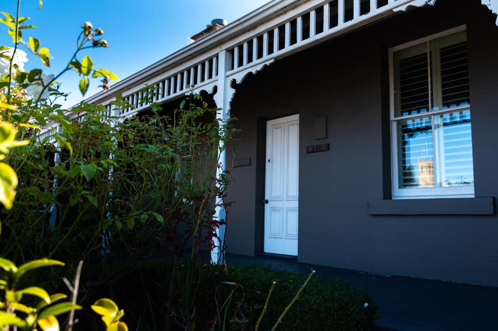 uma porta branca ao lado de uma casa em Freddy's Boutique Villas em Warrnambool