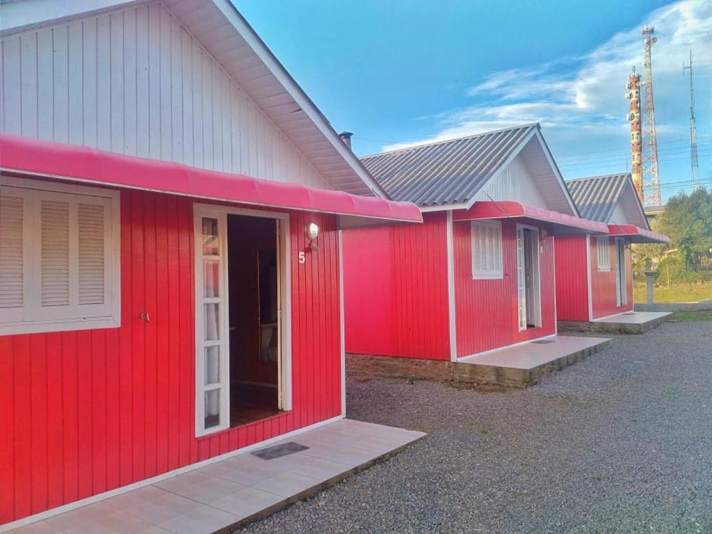 uma fila de casas com tinta vermelha. em Pousada Morada do Sol em Cambará