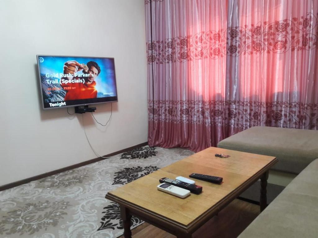 a living room with a tv and a coffee table at Комфортная квартира для гостей города in Qyzylorda
