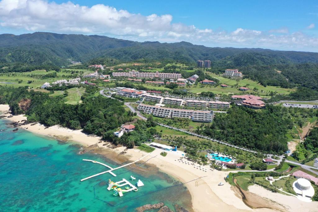 eine Luftansicht auf das Resort und den Strand in der Unterkunft Kanucha Bay Hotel & Villas in Nago