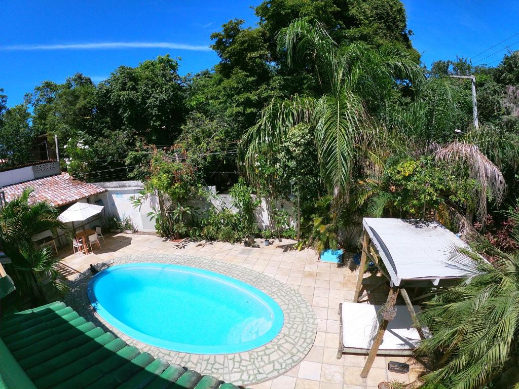 una piscina en un patio con mesa y sillas en Tropical Hostel, en Pipa