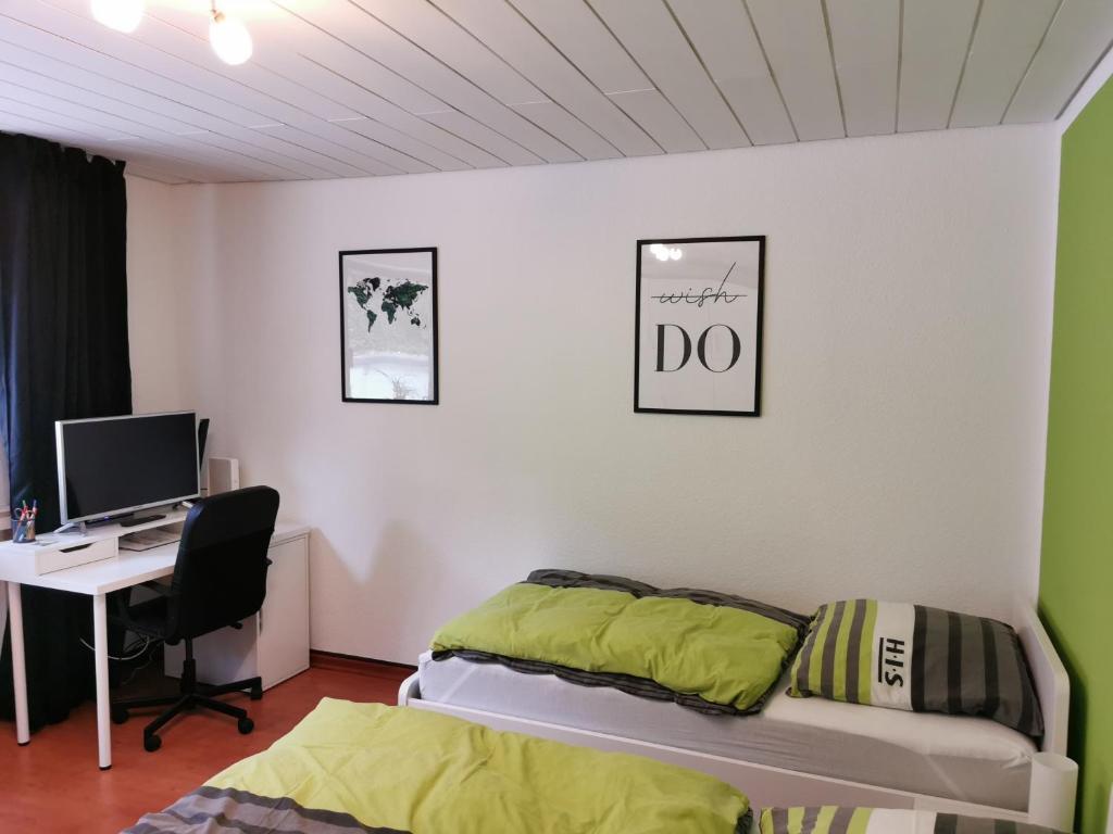 um quarto com uma cama, uma secretária e um computador em Ferienwohnung Sonnwald em Dusseldorf