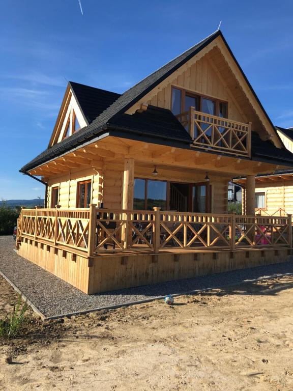 a large wooden house with a porch and a balcony at DOMEK POD LIMBAMI III in Kluszkowce