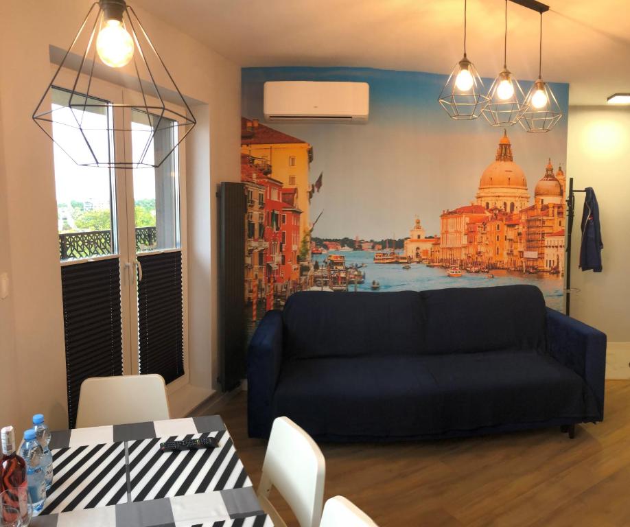 a living room with a couch and a painting on the wall at Klimatyzowany Apartament Wenecja z garażem podziemnym in Kielce