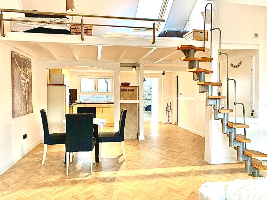 een woonkamer met een wenteltrap en een eetkamer bij Ginius Homes- Penthouse Düren in Düren - Eifel