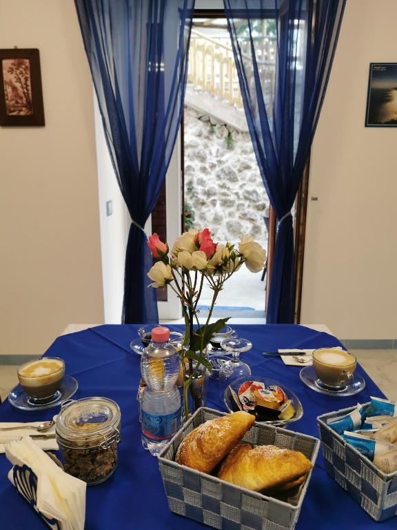 a table with a blue table cloth with bread and flowers at Astra in Agerola