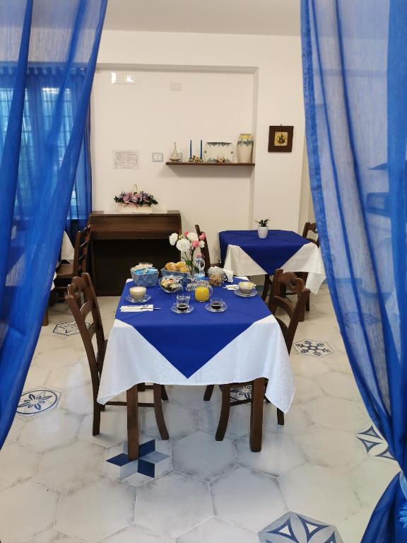 a dining room with two blue tables and a piano at Astra in Agerola