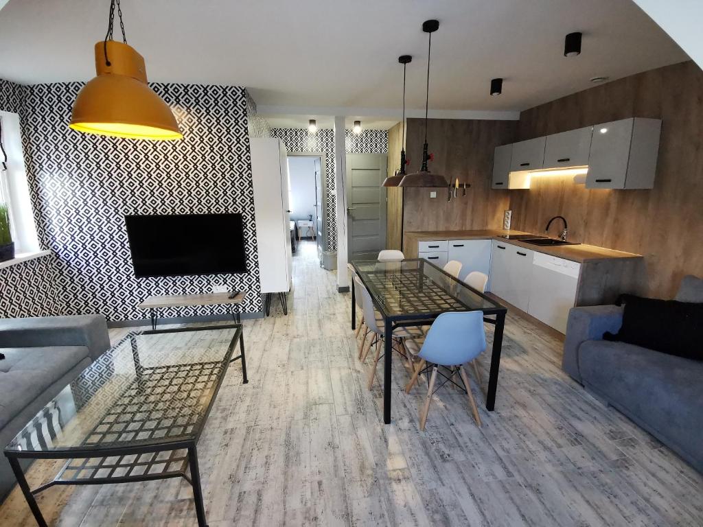 a kitchen and living room with a table and a couch at Apartamenty Majówka in Kłodzko