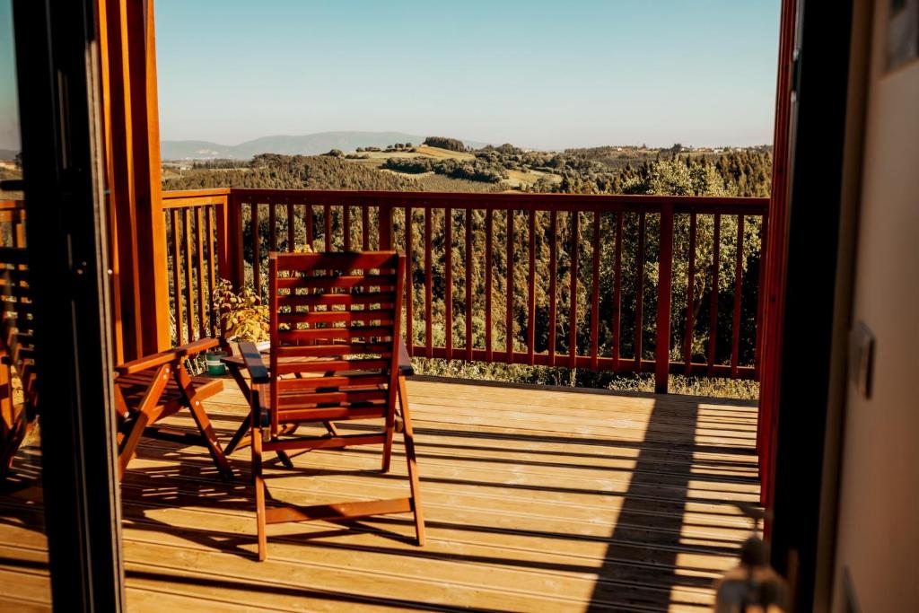 a wooden deck with a chair on a balcony at Cabanas da Colina in Bombarral